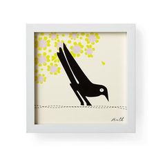 a black bird sitting on top of a white frame