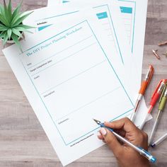 a person is writing on some paper with pens and pencils next to it, along with other office supplies