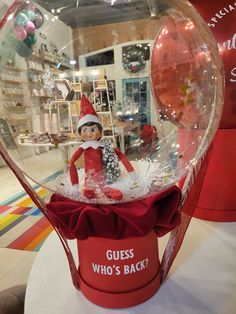 an elf in a red hat is inside a glass ball with the words guess who's back?