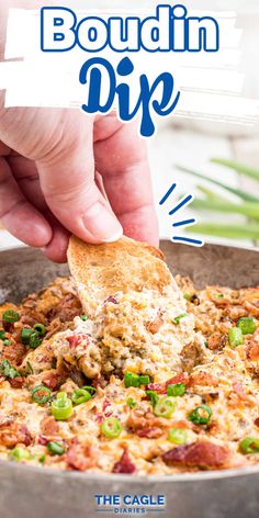 a hand dipping a piece of bread into a casserole