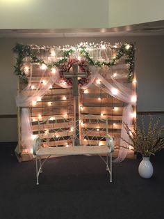 a white bench sitting under a window covered in lights