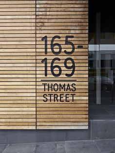 a sign on the side of a building that says thomas street and is made out of wood slats