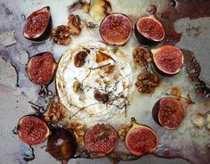 figs and other fruits are arranged in a circle on top of a dirty surface