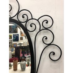 a mirror hanging on the side of a white wall next to a vase and other items