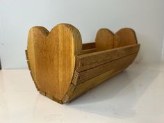 a wooden toy boat with two hearts on it