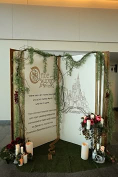 an open book with candles and greenery on the front, surrounded by other decorations