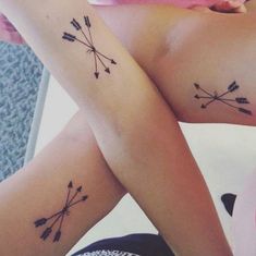 two women with matching tattoos on their arms, both showing arrows and the words love