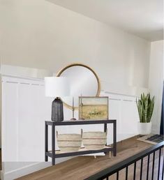 a living room with a mirror, couch and table in front of the door way