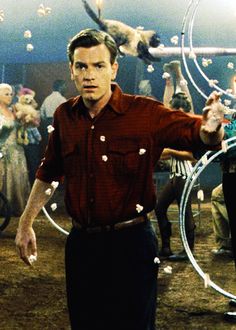 a man standing in front of a group of people with hoop rings on his hands