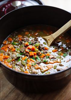 a wooden spoon in a pot filled with soup