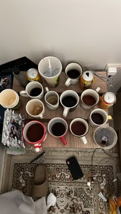 there are many coffee cups on the table