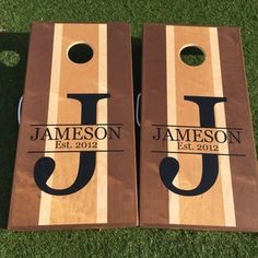 two personalized cornhole boards laying on the grass