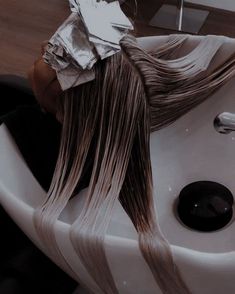 a woman with long hair sitting in a sink