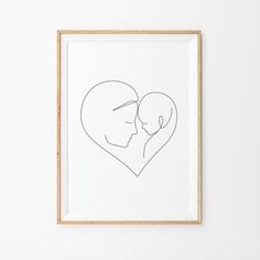 a couple's face in the shape of a heart framed in a wooden frame