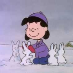 a person sitting in the snow surrounded by rabbits