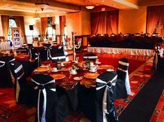 a banquet hall with tables and chairs covered in black cloths