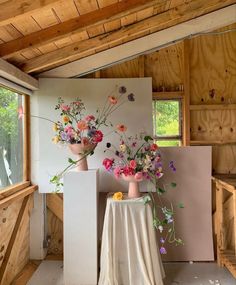 two vases filled with flowers on top of a table