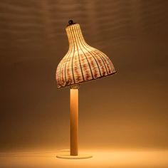 a lamp that is sitting on top of a wooden stand with a light shining in the background