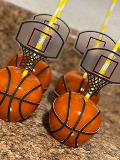 three orange basketballs sitting on top of each other in front of some yellow candles