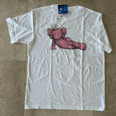 Uniqlo Kaws Unisex White And Pink Short Sleeve T-Shirt In Size M. Uniqlo And Kaws Have Done It Again And Collaborated To Create These Unique Limited Edition Design Tees. Material: 100% Cotton Measurement: Armpit To Armpit 21” Top To Bottom 27.5” White Relaxed Fit Top With Front Print, White Tops With Front Print And Relaxed Fit, White Short Sleeve Top With Front Print, White Top With Front Print And Relaxed Fit, White Top With Front Print In Relaxed Fit, White Printed Relaxed Fit Tops, White Cotton Shirt With Front Print, White Cotton Top With Front Print, Uniqlo Graphic Tee With Crew Neck