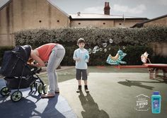 a woman blowing bubbles next to a child in a stroller and another person standing on the sidewalk