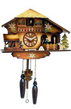 a wooden cuckoo clock hanging from the side of a wall with bells and decorations on it