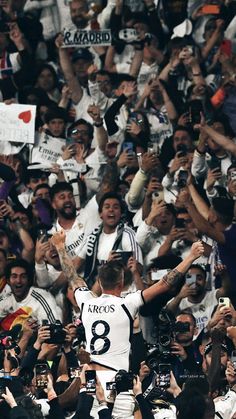 the soccer player is surrounded by fans and photographers