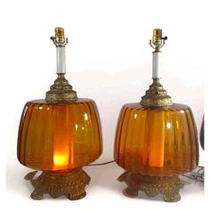 two yellow glass lamps sitting next to each other