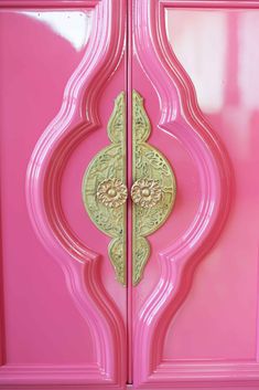 the door is painted pink and has gold designs on it's sides, as well as an intricately designed handle