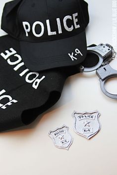 police cap, handcuffs and hat on white surface with other items to be used in the case