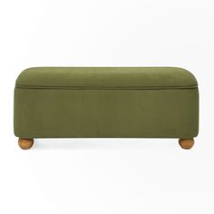 an upholstered bench with wooden legs and a green fabric cover on the back