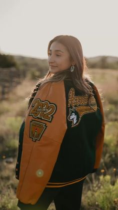 a woman wearing an orange and black jacket