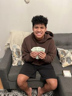 a person sitting on a couch holding money