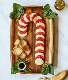 a wooden tray topped with sliced tomatoes and bread