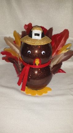 a glass turkey with a hat on it's head and feathers around its neck