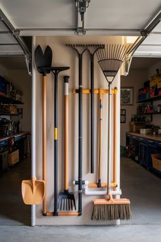 a garage with various tools hanging on the wall and brooms in front of it