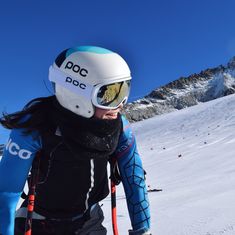 a person with skis and goggles walking in the snow