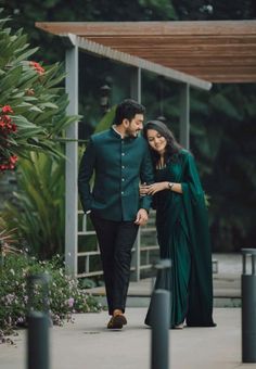 a man and woman dressed in green are walking together