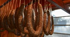 several sausages hanging from hooks in a kitchen