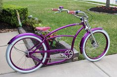 a purple bicycle is parked on the sidewalk