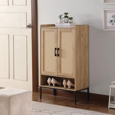 a wooden cabinet with shoes on it in a living room next to a white rug