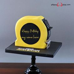 a yellow and black birthday cake sitting on top of a table