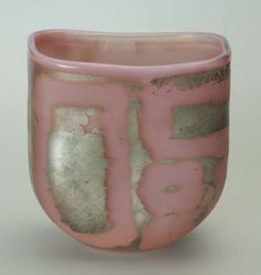 a pink and silver vase sitting on top of a table