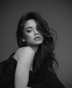 black and white photograph of a woman with long hair wearing a black dress posing for the camera