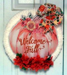 a welcome fall door hanger with flowers and a bow on it's head