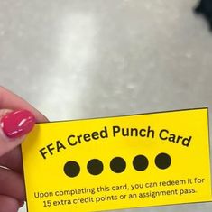 a person holding up a yellow card with black dots on it that says ffa credit punch card