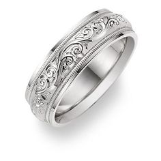 a wedding ring with filigrees and scrolls on the sides, set in white gold