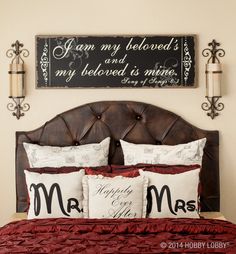 a bed with two pillows on top of it and a sign above the headboard