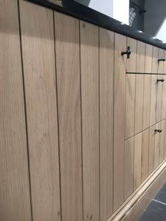 a kitchen with wooden cabinets and black counter tops on the side walk in front of it