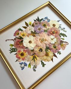 a painting of flowers in a gold frame